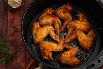 Cooking Chicken whole wings (Chicken 3 Joint Wing) with salt in Air Fryer pot.