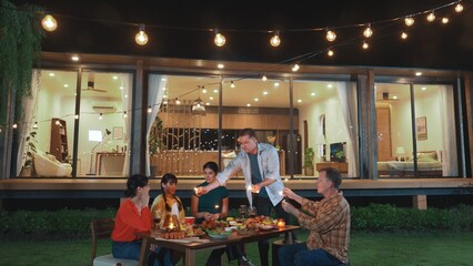 Happy family holding glowed sparkler in holiday celebration party at night. Lovely member enjoy...