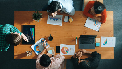 Top down view of manager holds tablet display increasing sales and placed on meeting table. Group of diverse business team clapping hands to celebrate successful product at meeting room Convocation.