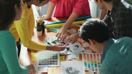 Top view of business team write graphic logo on meeting table with colorful sticky notes and design while explain idea. Project manager sharing idea and explain concept art to smart team. Symposium.