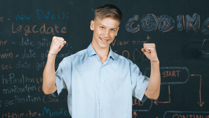 Handsome adult standing at blackboard with engineering code or prompt while attend in STEM class....