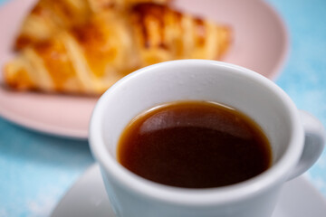 breakfast with coffee and croissant on blue background
