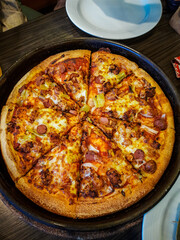 pizza on a wooden board. 
Top view of the pizza