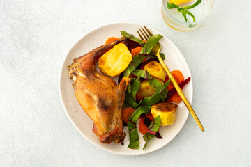 Indulge in a flavorful feast with tender baked rabbit, crispy potatoes, and vibrant carrot salad, creating a balanced, gourmet meal perfect for any festive occasion