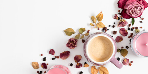 Autumn composition with cup of coffee, dry roses and candles. Autumn background in pastel colors with dried pink flowers and leaves. Flat lay, top view, copy space