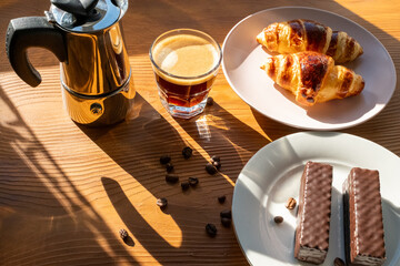 breakfast with coffee and croissant on wooden background