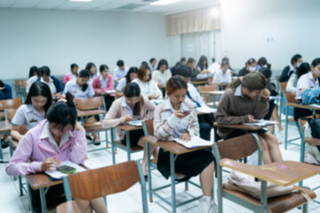 A classroom filled with students taking an exam, captured with a blurred focus, symbolizing academic testing, education, and concentration.