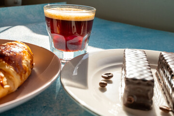 breakfast with coffee and croissant on blue background