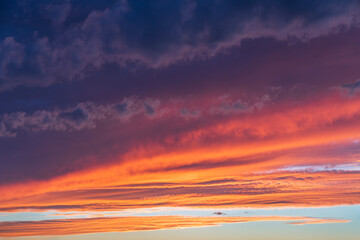 Glowing real sky at sunset texture background overlay. Dramatic red and orange clouds.