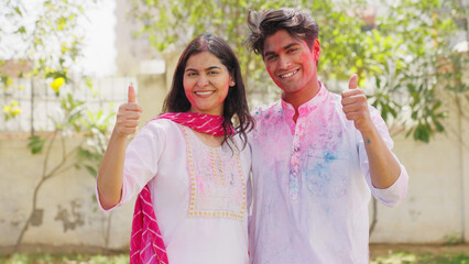 Indian Couple Showing Thumbs Up with Holi Colors in Face