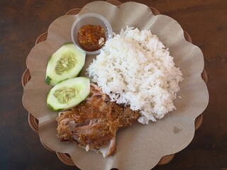 Kremes fried chicken is fried chicken mixed with flour, seasoned with turmeric, garlic, shallots which is then fried using coconut oil, which is served with rice, chili sauce and lalap.