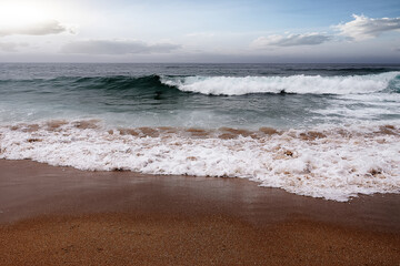 Seascape with waves breaking on the beach.