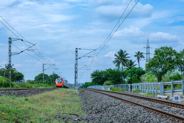 Saffron coloured Vande Bharat Express near Pune India. This is a tri-weekly train between Pune and...