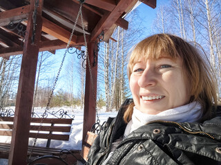 Smiling Woman on the swing on a Sunny Spring, Winter or early autumn Day Outdoors on nature