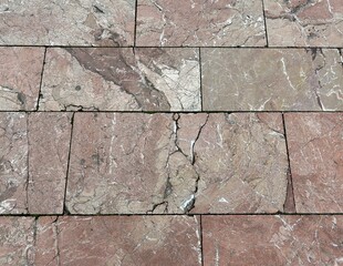 Rose beige brown colored vintage virgin stone or granite pavement with cracks, garden design and landscaping, walkway or square, road construction, background, texture, close up