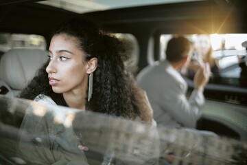 Medium shot of Middle Eastern female celebrity get tired of paparazzi sitting in back seat of car...