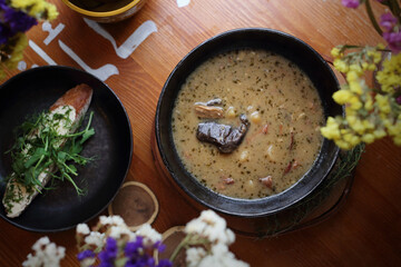 Zalewajka, a traditional country Polish soup, with potatoes, homemade sourdough, bay boletes and thyme, top view.