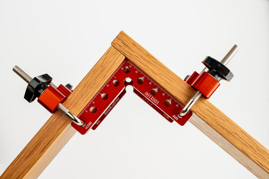 set of red anoodised aluminium woodworking cabinet corner clamps with fixing bolts and knobs to create a right angle