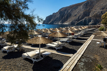 Ombrelloni di paglia sulla spiaggia di Kamari beach a Santorini Grecia
