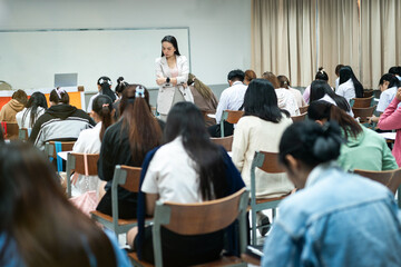 A teacher carefully monitors students taking an exam in a classroom, ensuring focus and discipline during academic assessment.