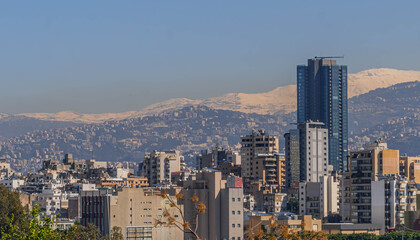 Obraz premium The Beirut panorama view in Lebanon, with the modern skyscrapers, Lebanese architecture and snow covered mountains. 