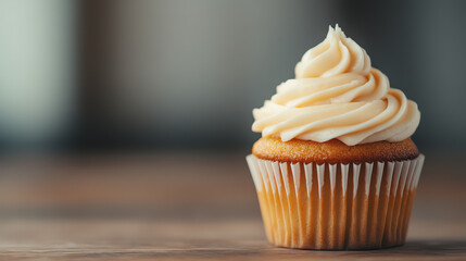 Delicious cupcake with creamy frosting, presented on a rustic wooden surface. Perfect for dessert lovers and baking enthusiasts.