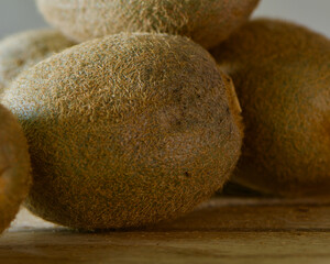 kiwi fruits, cutting board, still life, green flesh, brown skin, seeds, texture, close-up, sliced kiwi, whole kiwi, juicy, tropical fruit, vibrant color, healthy snack, fresh produce, fruit arrangemen