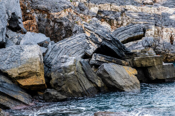 Eindrückliche Felsformationen, Wälder und raues Meer mit wunderschönen schwarzen und goldenen Felsen