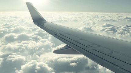 Obraz premium Airplane in flight, close-up of airplane wing against a bright sky, clouds in view