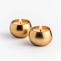 Two elegant golden candles with a warm flame, soft glow on a white isolated background.