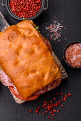 Focaccia with salami, cheese, tomatoes, arugula, salt, spices and herbs