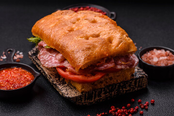 Focaccia with salami, cheese, tomatoes, arugula, salt, spices and herbs