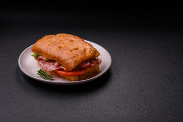 Focaccia with salami, cheese, tomatoes, arugula, salt, spices and herbs