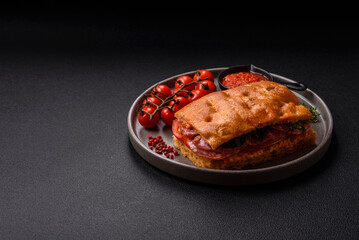 Focaccia with salami, cheese, tomatoes, arugula, salt, spices and herbs