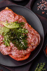 Focaccia with salami, cheese, tomatoes, arugula, salt, spices and herbs