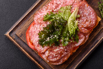 Focaccia with salami, cheese, tomatoes, arugula, salt, spices and herbs