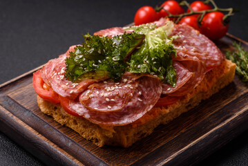 Focaccia with salami, cheese, tomatoes, arugula, salt, spices and herbs