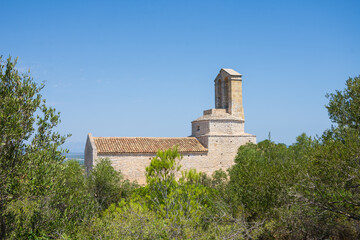 View between trees of the castle church, Olerdola, Spain, Europe, August, 8, 2024, horizontal