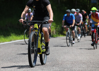group of cyclists competing on a gravel bike race course with many paved road