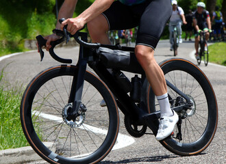 black professional racing bike and the cyclist with muscular legs pedaling