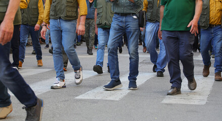 Many legs of people marching in the street during a peaceful protest and strike