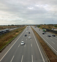 Fototapeta premium very wide four-lane highway with cars and vehicles speeding along the road seen from above