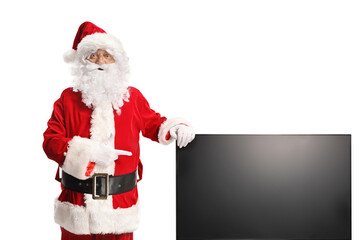 Naklejka premium Santa claus pointing at a tv screen