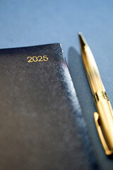 2025 with golden penn, blue diary on blue background