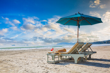 Beach tables and umbrellas,Beaches and sun tables in Thailand,Row of empty sun loungers and orange...