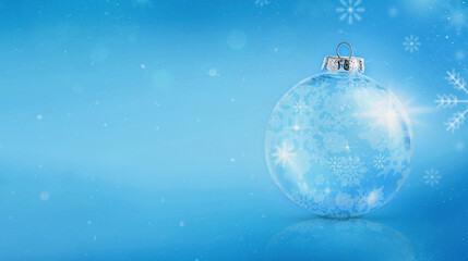 Glass sparkling ball with snowflake pattern stands on blue background. Copy space