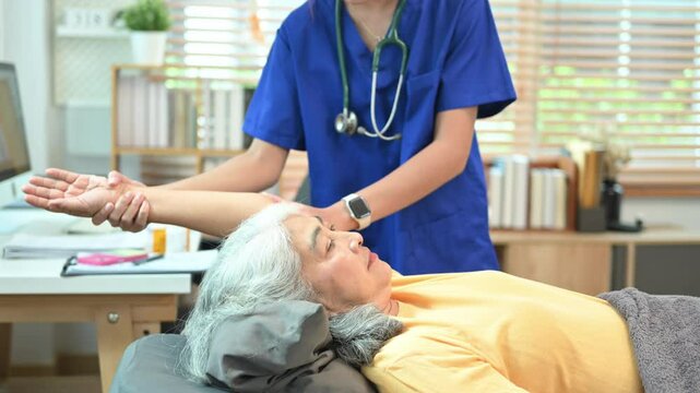 Female physiatrist examining elderly patient frozen shoulder symptoms in a rehabilitation clinic