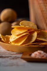 Potato chips on a wooden table.
