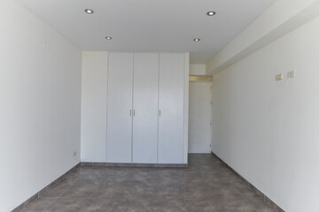 habitacion de departamento con closet empotrado con acabados de madera