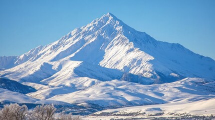 A snow-capped mountain peak with a clear blue sky.